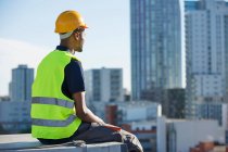Onstruction worker sitting on ledge — Stock Photo