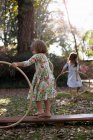 Sisters playing with plastic hoops — Stock Photo
