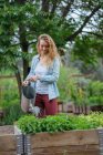 Молода жінка поливає рослини — стокове фото