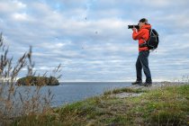 Homme photographiant le littoral — Photo de stock