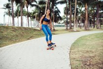 Donna skateboard attraverso il parco — Foto stock