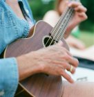 Mulher madura, ao ar livre, jogando ukulele — Fotografia de Stock