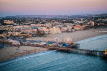 Pier and beach with amusement park — Stock Photo