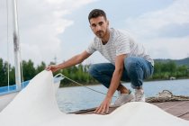 Junger Mann faltet Boote — Stockfoto