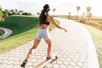 Молода жінка скейтбординг в парку — стокове фото