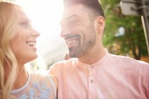 Couple in sunlight face to face smiling — Stock Photo