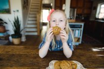 Menina comer muffin — Fotografia de Stock