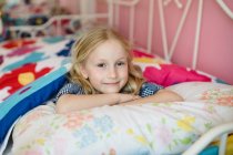 Retrato de menina deitada na cama — Fotografia de Stock