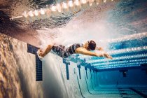 Nuotatore in piscina, vista laterale — Foto stock