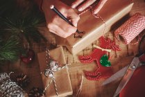 Женщина маркирует рождественский подарок — стоковое фото
