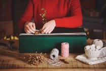 Женщина упаковывает рождественский подарок — стоковое фото