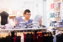 Young man looking at clothes — Stock Photo
