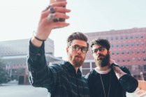 Male hipsters taking smartphone selfie — Stock Photo