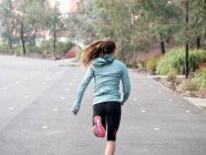 Female runner running by park — Stock Photo