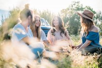 Freunde im hohen Gras picknicken — Stockfoto