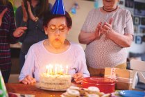Senior woman blowing out candles — Stock Photo