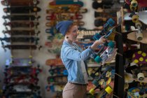 Mulher trabalhando na loja de skate — Fotografia de Stock