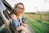 Frau schaut aus fahrendem Auto — Stockfoto
