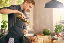 Chef drizzling oil on bowl — Stock Photo