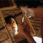 Mirror image of man shaving — Stock Photo