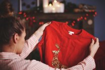 Woman holding christmas jumper — Stock Photo