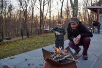 Мальчик и отец пасут огонь — стоковое фото
