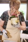 Mujer oliendo maceta planta - foto de stock