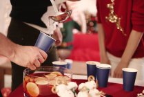 Cropped shot of young man serving punch to friends at christmas party — Stock Photo