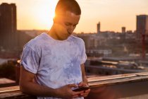 Uomo guardando smartphone al tramonto — Foto stock