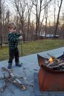 Мальчик собирает дрова для патио — стоковое фото