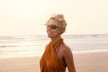 Жінка на пляжі дивиться геть — стокове фото