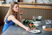 Junge Frau am Küchentisch — Stockfoto