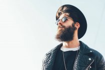 Hipster wearing sunglasses and trilby looking up — Stock Photo