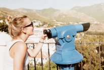 Mujer por telescopio en plataforma de visualización - foto de stock