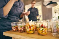 Chef filling plastic containers — Stock Photo