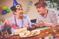 Frauen servieren Geburtstagstorte auf Party — Stockfoto