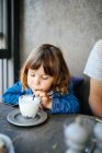 Girl sipping milk in cafe — Stock Photo