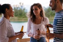 Three friends holding bottles of beer — Stock Photo