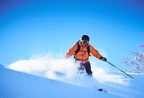 Hombre esquiando montaña abajo - foto de stock