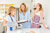 Mother and daughters baking in kitchen — Stock Photo