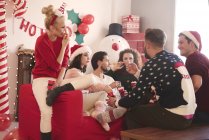 Junge Frauen und Männer essen Popcorn auf Sofa bei Weihnachtsfeier — Stockfoto