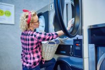 Женщина убирает белье из сушилки — стоковое фото