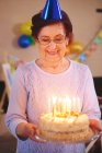 Seniorin mit Geburtstagstorte — Stockfoto