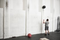 Hombre lanzando pelota de fitness - foto de stock