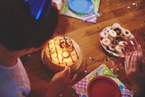Старша жінка дивиться на торт на день народження — стокове фото