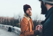 Male hipsters fist bumping in park — Stock Photo