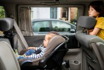 Baby and big brother in car — Stock Photo