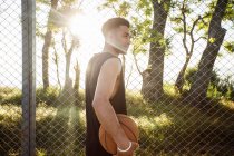 Jovem segurando basquete — Fotografia de Stock