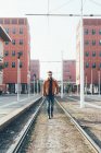 Homme marchant le long des lignes de tramway ville — Photo de stock