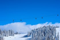 Cable cars over snow covered mountains — Stock Photo